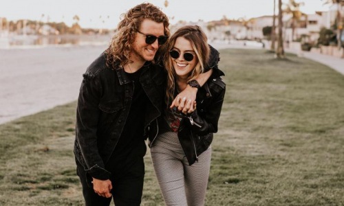 a couple walks on grassy area in open neighborhood lot