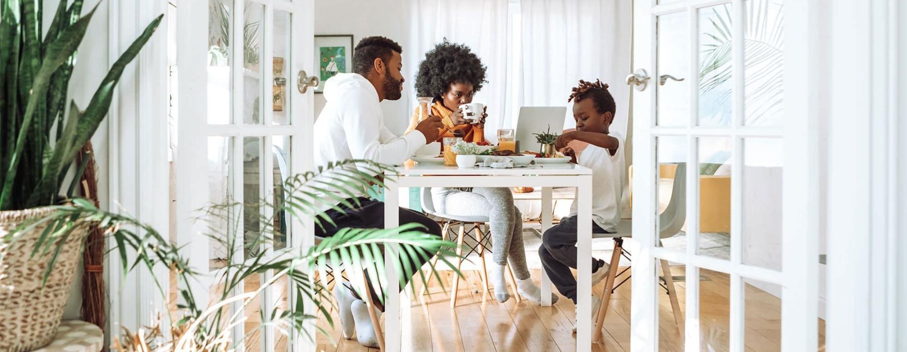 young family of three eat together at the breakfast table